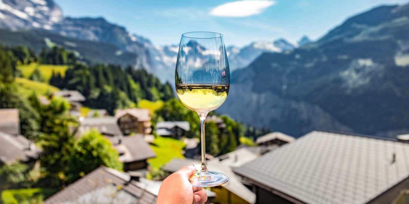 A beautiful mountain view in contrast to a man holding a wine glass. Know contrast in terms of wine flavors and food can help you also to pair wine and food