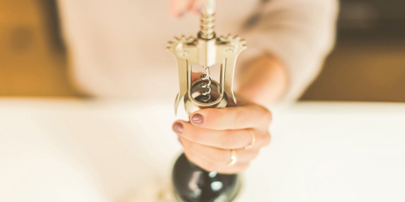 woman using a wine opener 